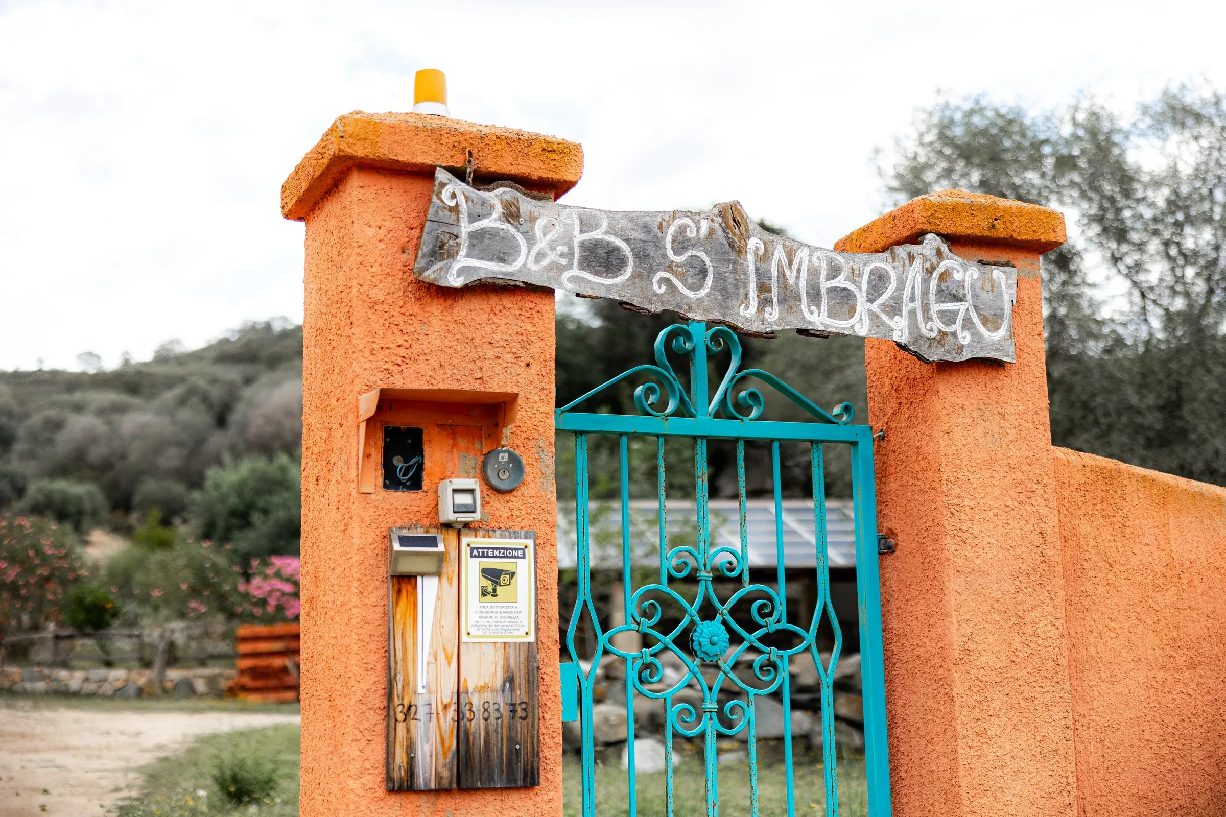Portail turquoise sous l’enseigne de S’imbragu